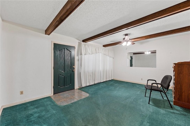 living area featuring ceiling fan, beam ceiling, carpet floors, and a textured ceiling