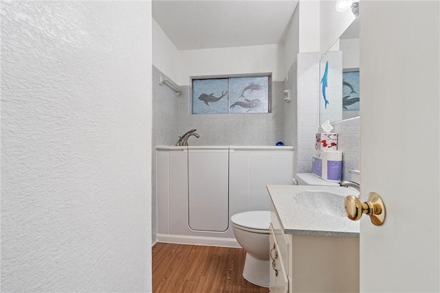 bathroom with hardwood / wood-style flooring, vanity, and toilet