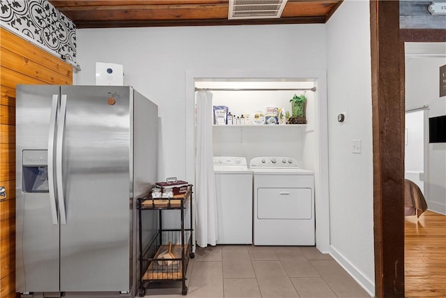 laundry area featuring light tile patterned floors and separate washer and dryer