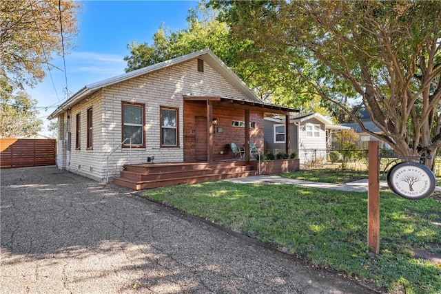 bungalow-style home featuring a front lawn