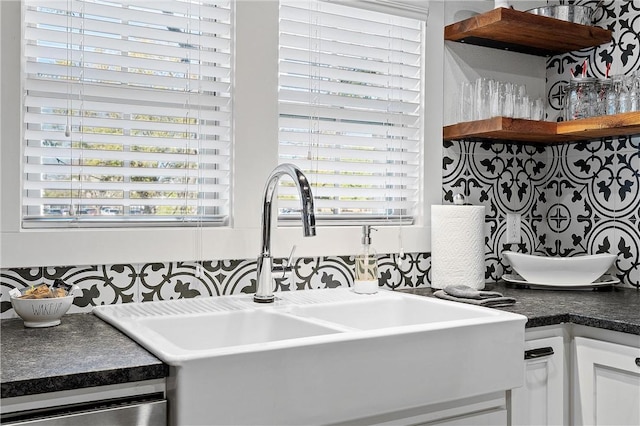 kitchen with dishwasher, sink, and white cabinets