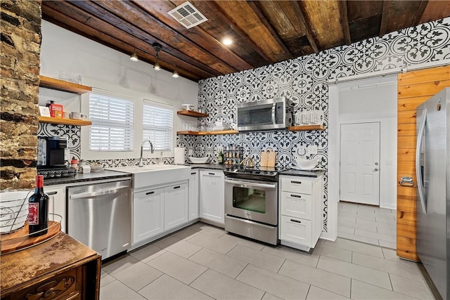 kitchen featuring wooden ceiling, backsplash, white cabinets, light tile patterned floors, and stainless steel appliances