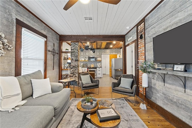 living room featuring beamed ceiling, ceiling fan, wood ceiling, and light hardwood / wood-style flooring