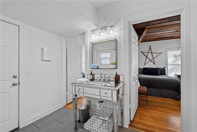 bathroom featuring beamed ceiling, hardwood / wood-style floors, vanity, and wood ceiling