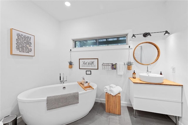 bathroom featuring a tub to relax in, tile patterned floors, and vanity