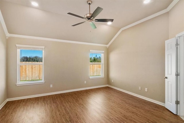 empty room featuring dark hardwood / wood-style floors, vaulted ceiling, ceiling fan, and ornamental molding