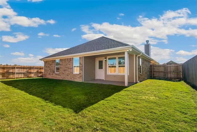 rear view of house with a yard and a patio