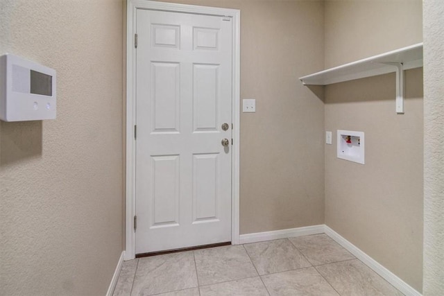 clothes washing area featuring washer hookup and light tile patterned floors