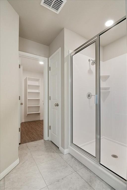 bathroom featuring tile patterned flooring and an enclosed shower