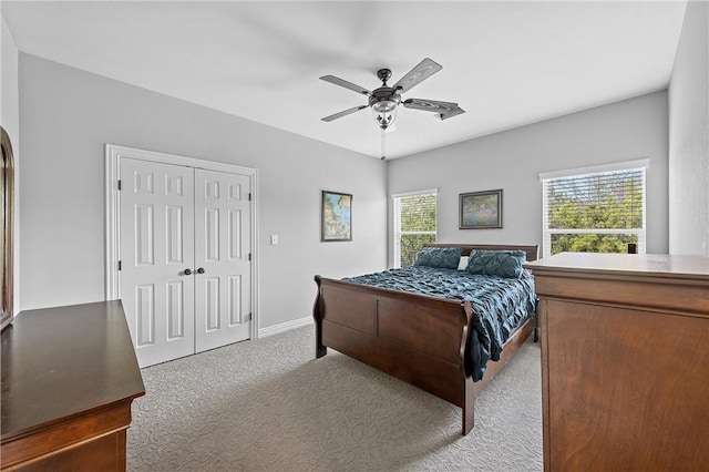 carpeted bedroom with a closet, multiple windows, and ceiling fan