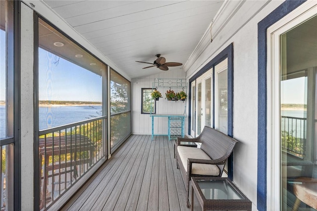 sunroom with ceiling fan, a water view, lofted ceiling, and wooden ceiling