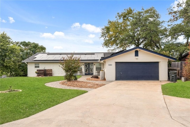 ranch-style home with solar panels, a front lawn, and a garage