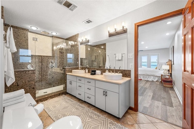 bathroom with vanity, wood-type flooring, a textured ceiling, and walk in shower