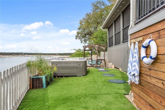 view of yard with a pergola, a water view, and a hot tub