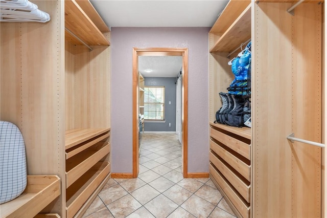 walk in closet with light tile patterned floors