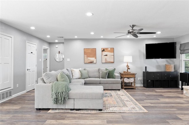 living room featuring wood-type flooring and ceiling fan