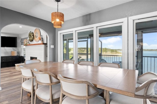 dining room with hardwood / wood-style floors and a water view