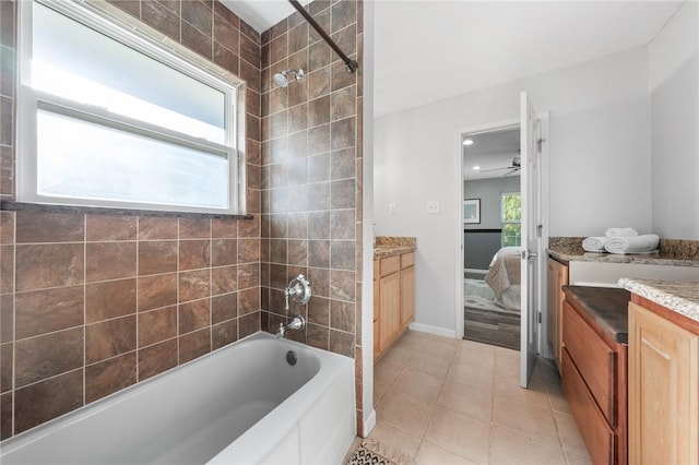 bathroom featuring tile patterned flooring, vanity, tiled shower / bath combo, and ceiling fan