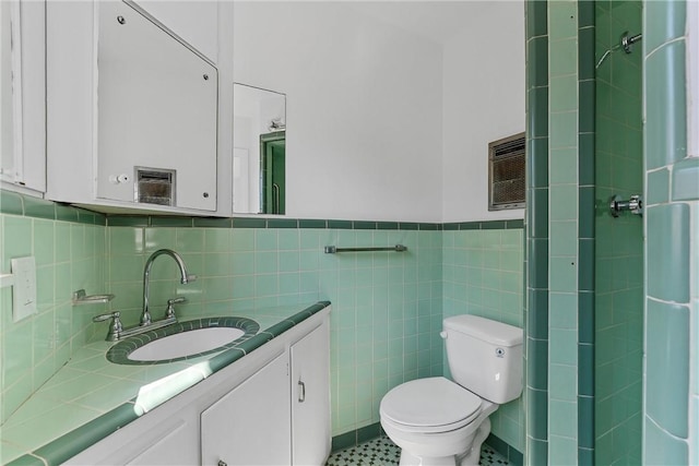 bathroom with vanity, tile walls, and toilet