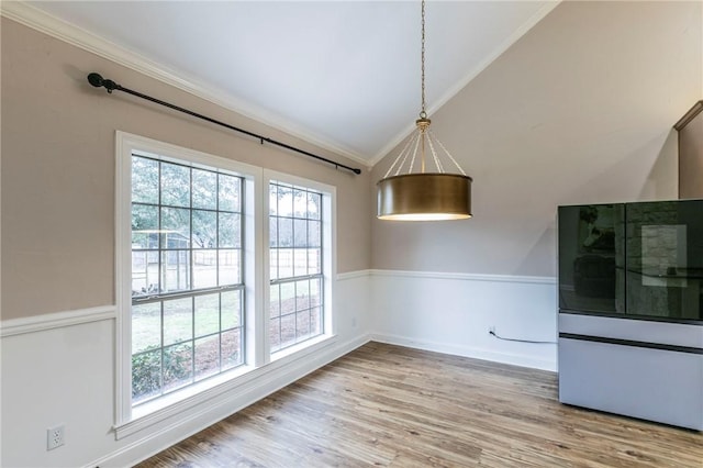 unfurnished dining area with hardwood / wood-style floors, vaulted ceiling, a healthy amount of sunlight, and crown molding