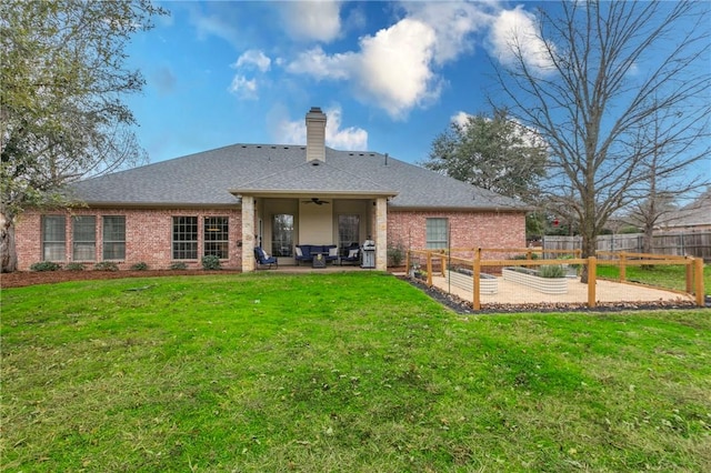 rear view of property featuring ceiling fan, a yard, and a patio