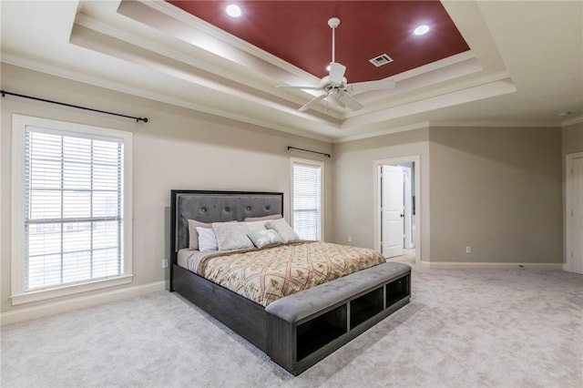 bedroom with a tray ceiling, ceiling fan, carpet flooring, and ornamental molding