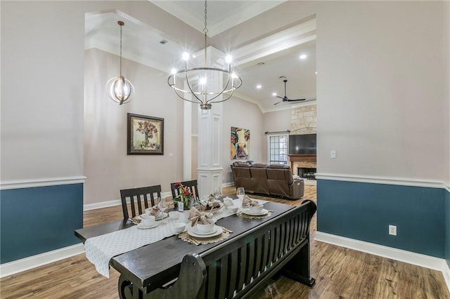 dining area with ornate columns, crown molding, wood-type flooring, and ceiling fan with notable chandelier