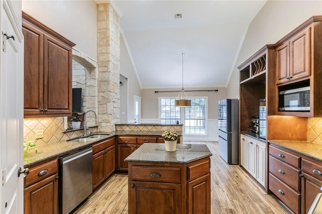 kitchen with appliances with stainless steel finishes, light hardwood / wood-style flooring, lofted ceiling, and sink