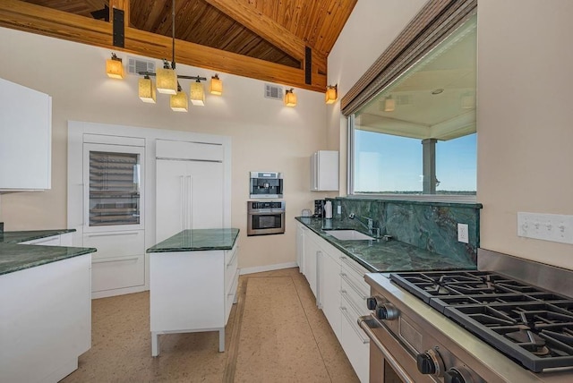 kitchen featuring sink, white cabinetry, tasteful backsplash, decorative light fixtures, and stainless steel appliances