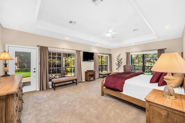 bedroom featuring light carpet, access to exterior, a tray ceiling, and ceiling fan