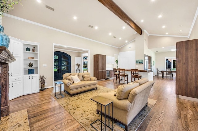 living room featuring beam ceiling, ornamental molding, high vaulted ceiling, and light wood-type flooring