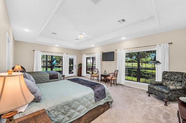 bedroom featuring access to exterior, a tray ceiling, ceiling fan, and carpet