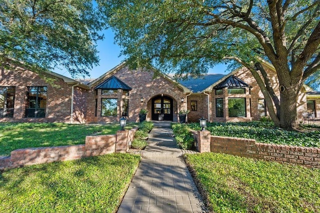 tudor house with a front lawn and french doors