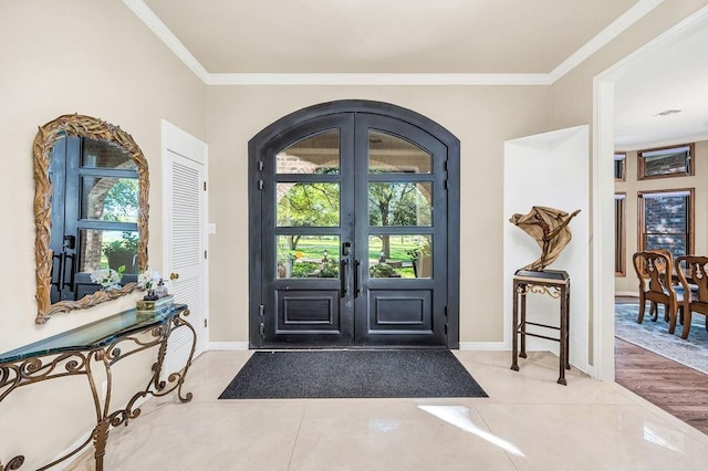 tiled foyer entrance featuring french doors and ornamental molding