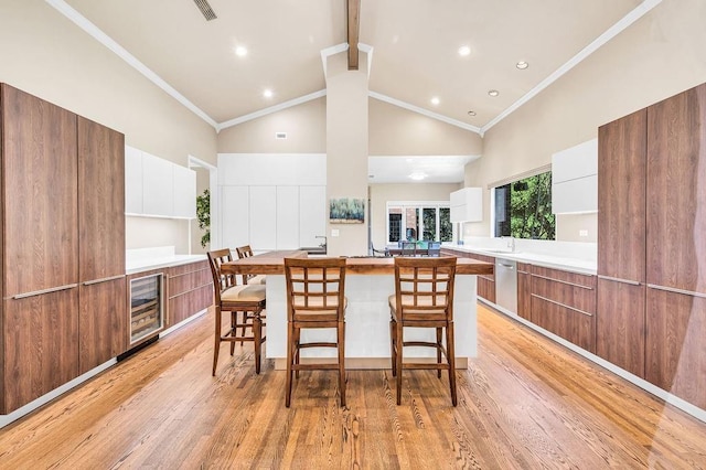 kitchen featuring ornamental molding, a breakfast bar, and white cabinets