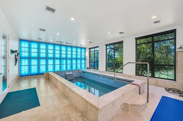 view of swimming pool featuring an indoor hot tub