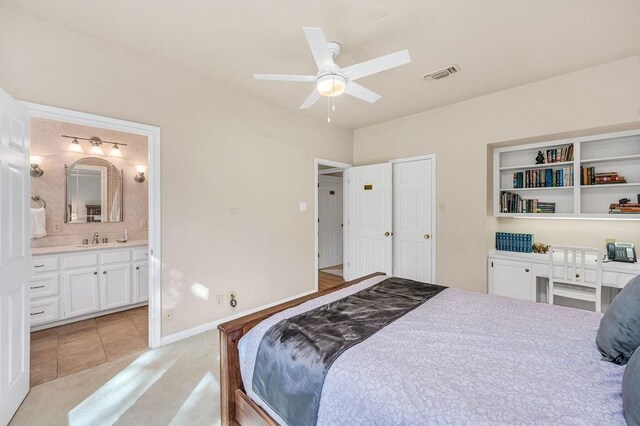 bedroom featuring sink, ensuite bath, and ceiling fan