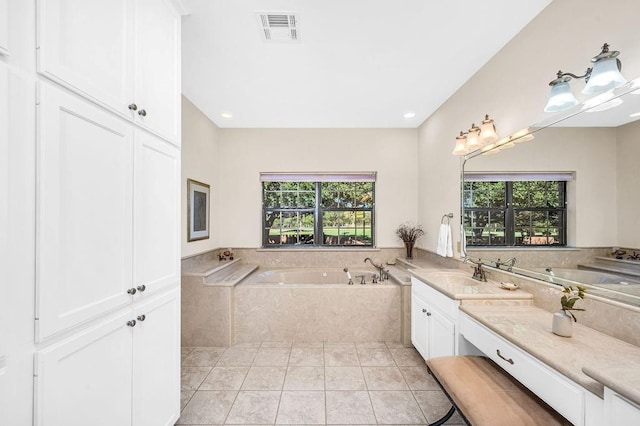 bathroom featuring vanity, tile patterned flooring, and a relaxing tiled tub