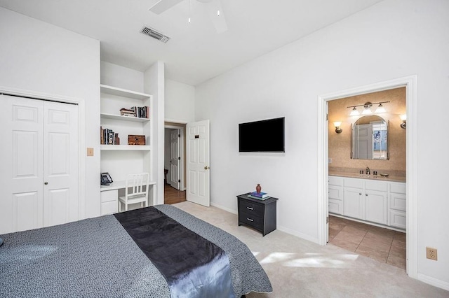 carpeted bedroom with connected bathroom, sink, a closet, and ceiling fan