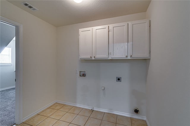 clothes washing area with electric dryer hookup, cabinets, hookup for a gas dryer, washer hookup, and a textured ceiling