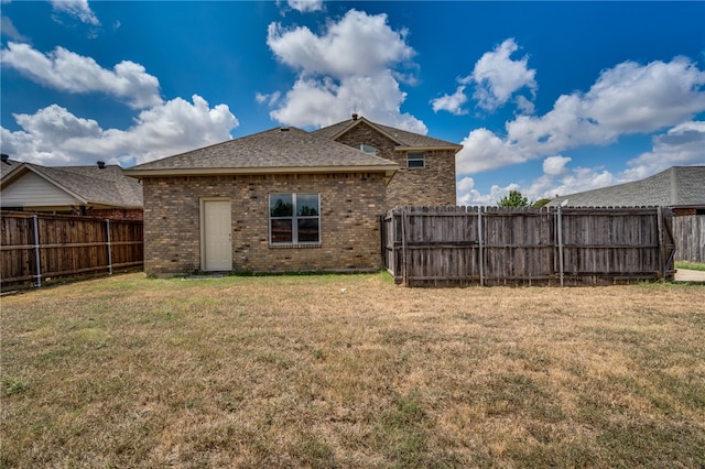 back of property featuring a lawn