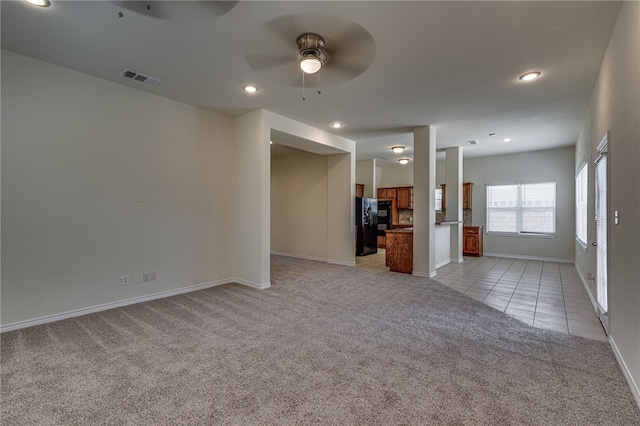 unfurnished living room with light carpet and ceiling fan