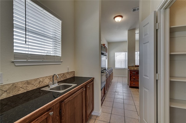 kitchen with sink, light tile patterned flooring, and oven