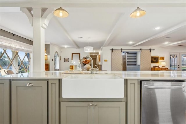 kitchen with open floor plan, a sink, stainless steel dishwasher, and a barn door