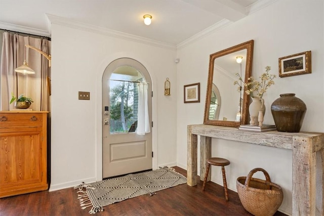 entrance foyer with arched walkways, ornamental molding, dark wood-style flooring, and baseboards