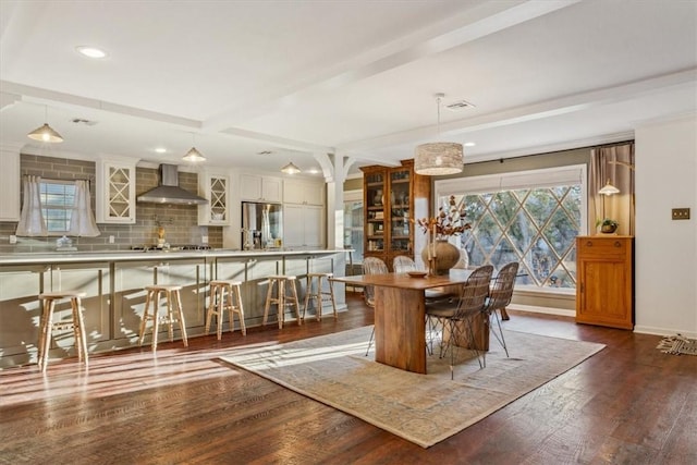 dining room featuring baseboards, beamed ceiling, dark wood finished floors, and a healthy amount of sunlight