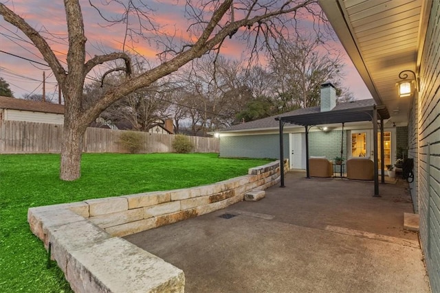 yard at dusk with a patio, fence, and a pergola