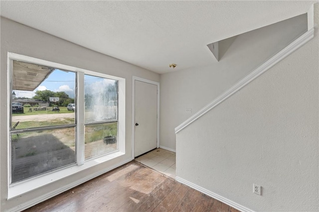 foyer entrance featuring a textured ceiling and light hardwood / wood-style flooring