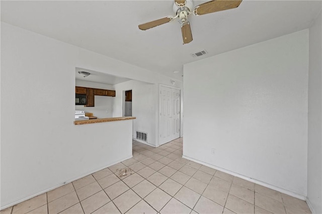 unfurnished room featuring ceiling fan and light tile patterned floors