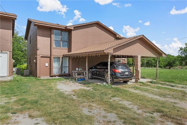 rear view of property featuring central AC, a yard, and a carport